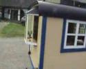 Lokomobil mit altertümlichen Wohnwagen und Bowlerhut-Besatzung