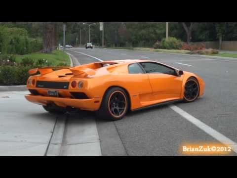 VT - BrianZuk records an insane orange Lamborghini Diablo 6.0 with black wheels with an orange pin stripe, and an aftermarket exhaust accelerating down a street l...