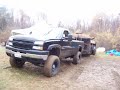 Lifted Duramax pullin dump trailer out of mud