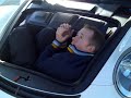 Vicki Butler Henderson showing the boot space of a Porsche