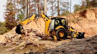 See a Cat backhoe loader's thumb attachment in action.