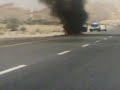 جني يركض نحو سيارة تحترق في طريق خارجي يؤدي إلى مسقط عاصمة سلطنة عمان