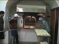 Cottura del pane casalingo pugliese in forno a legna tradizionale.