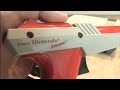 Classic Game Room HD reviews the Nintendo ZAPPER light gun for the NES video game system. The NES Zapper came with NES systems back in the day and has a copyright on the orange and NES colored unit of 1985. There were numerous NES games that used the light gun such as Operation Wolf, Duck Hunt and Freedom Force. Although light gun video games and shooting games for home consoles is nothing new or revolutionary, this NES Zapper always stands out in a crowd because of its bright colors and ...