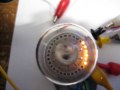 This strange device is an Ericsson GCA10G 'direct drive' glow transfer counting tube, a dekatron specially designed to be coupled to a Nixie display tube without any intermediate hardware. The GCA10G has a series of ten supplemental anodes arranged equidistantly around the inside of the tube, one for each output cathode. Nixie tube cathodes are connected to these anodes; as the glow transfer passes by a supplemental anode, the flow of current will jump between it and the primary anode ...