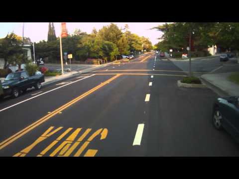 Cyclists Riding in and out of a Downhill Door Zone Bike Lane