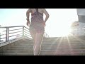 BACKSIDE OF A WOMAN RUNNING UP AN OUTDOOR STAIRS