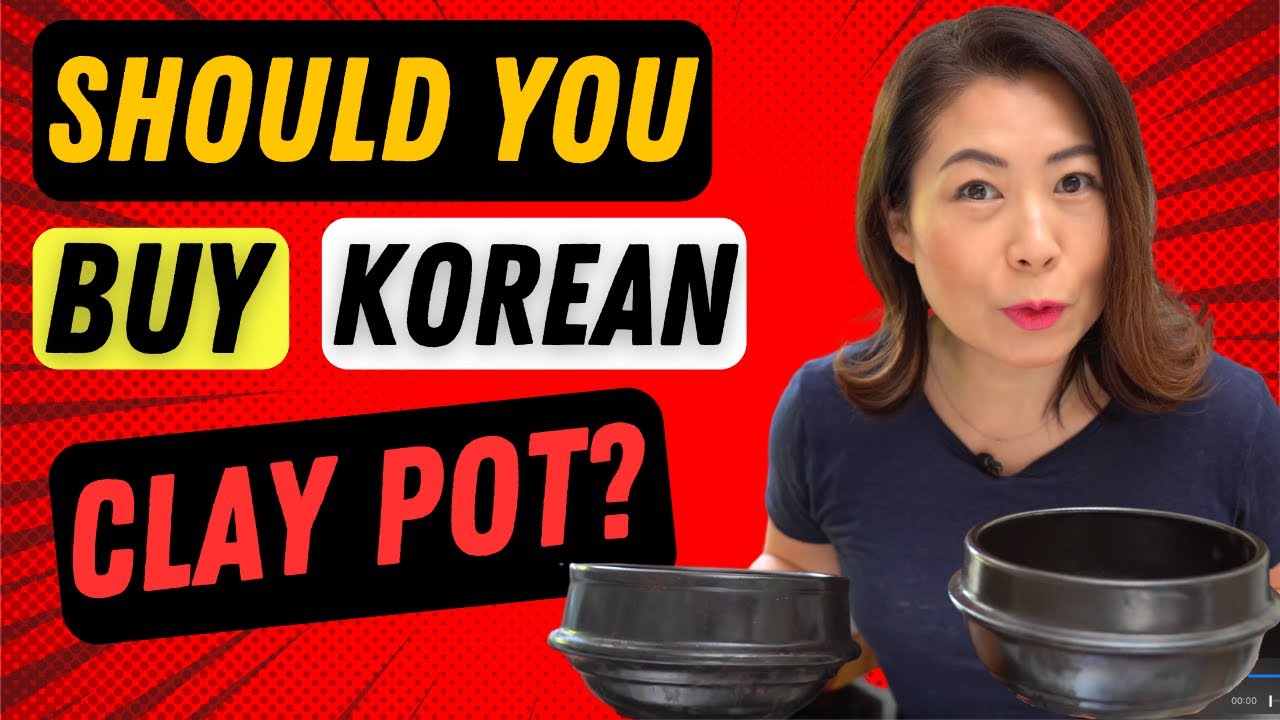 A Korean ddukbaegi earthenware clay pot bubbling on a stovetop with a soybean stew simmering inside showing the natural clay color