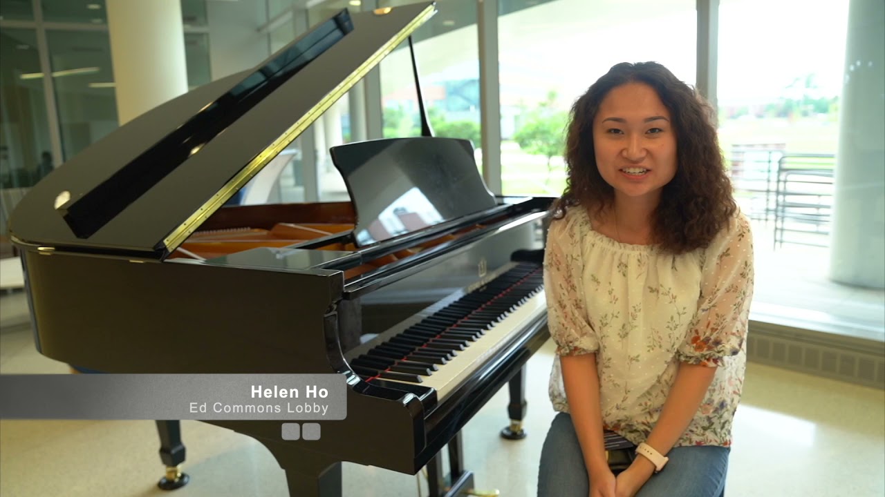 A DCG student sits at a piano in the DCG lobby