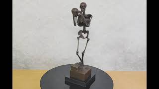 Bronzová socha kostry s lebkou – soška kostlivec