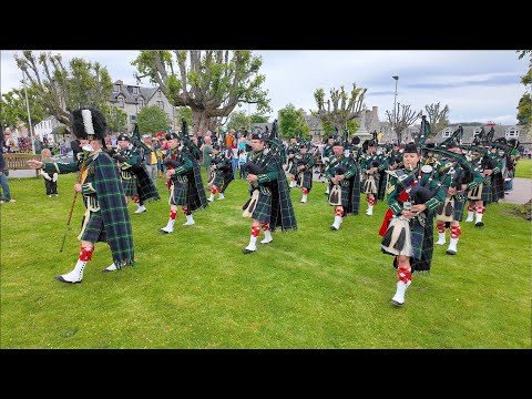 Drum Major leads Huntly Pipe Band playing Dawning of the Day before 2024 Tomintoul Highland Games