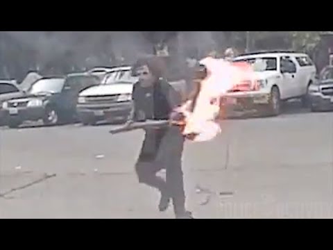فيديو: أمريكي يُلقي بشعلة نيران ملتهبة في سيارة شرطة والضابط بداخلها