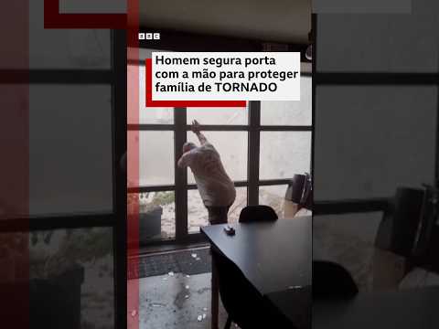 Homem segura porta com a mão para proteger família de tornado na França