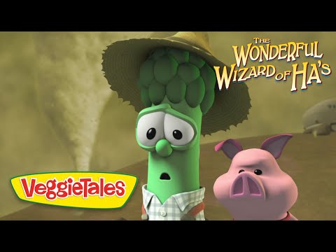 Animated VeggieTales scene: a green cucumber and a pink pig look surprised, wearing a hat, with 'The Wonderful Wizard of Ha's' logo in the corner.