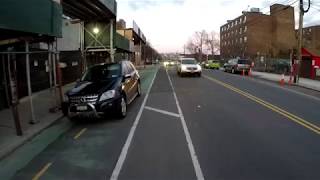Mercedes SUV drives on a 2 way Vernon Boulevard bike lane in Astoria, Queens, NYC - January 24, 2018