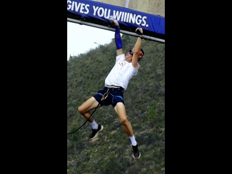 Man uses monkey bars to cross bridge in South Africa