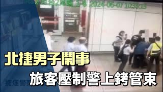 男子搭捷運忽鬧事遭旅客壓制  警到場上銬管束