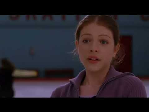 Official trailer frame: Casey spins out of a sit spin as arena lights bloom behind her
