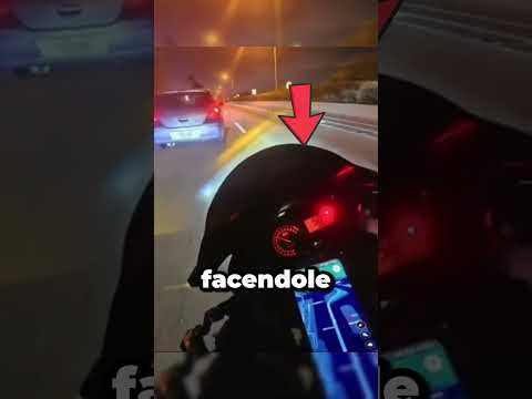 Motociclista cerca di fermare un'auto della polizia