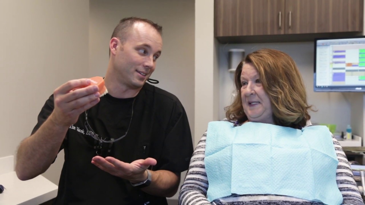 Dentist near Lincoln showing a denture to a patient
