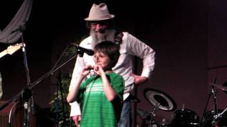 Noah C shows Mo Grundy how he taught himself to play the harmonica