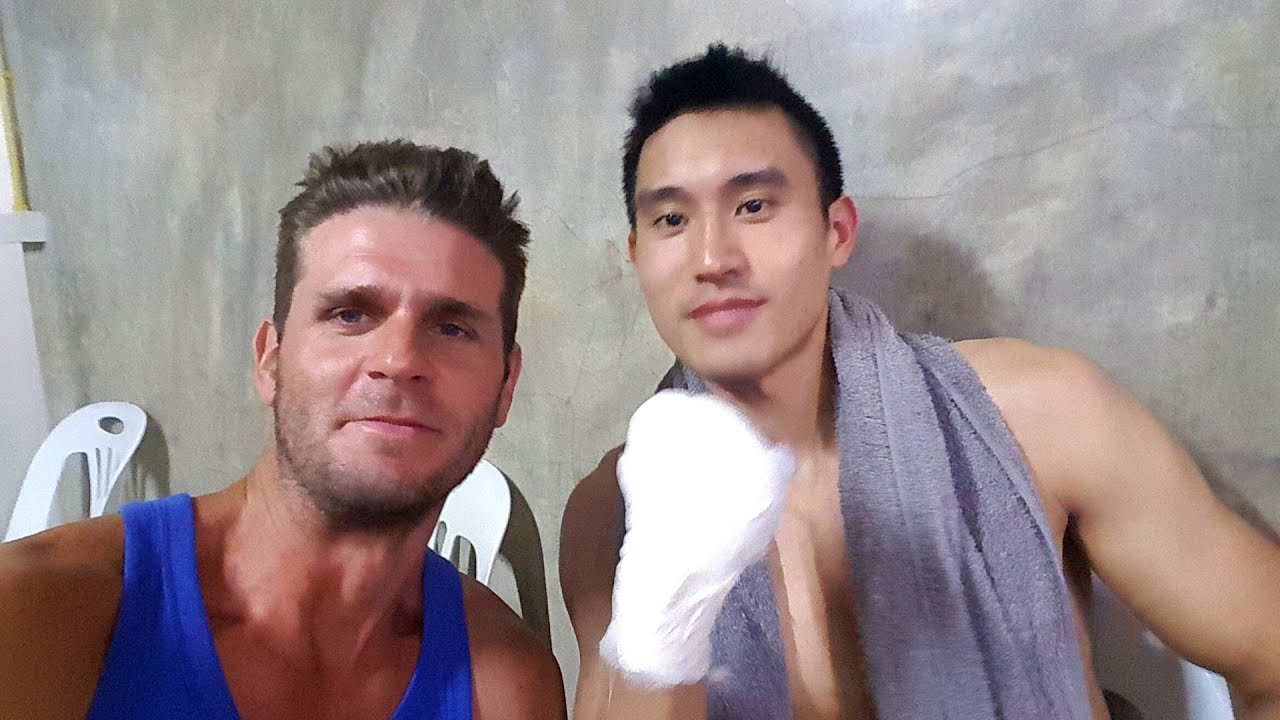 A traveler journeys to the vibrant Chiang Mai Boxing Stadium, captivated by the spectacle of a Muay Thai fight.