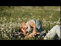 Slow motion of a young happy mother and child in a flower field at sunset.