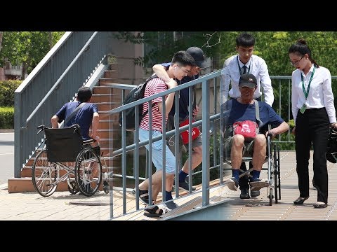 老人過天橋時遇到困難，有路人二話沒說幫他抬起輪椅！