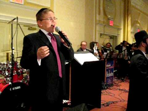 Dovid Dachs singing V'hoo at a chuppa with shira choir