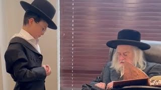 הרב הגדול של מונקאץ' מעלה את טפילין לסולן הילד המפורסם מאיר רוזינגר