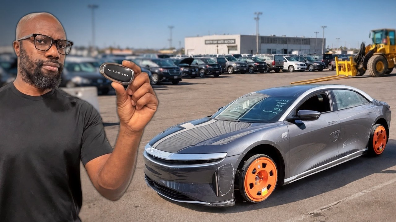Damaged Lucid Air electric sedan being winched off a car transport truck at a repair shop