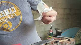 sanding the k-bar knife to get it ready to epoxy the handle the guard in the button cap