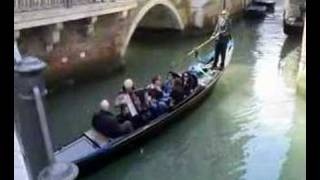 Tourists in Venice, Italy, on a Gondola trip through canals with melody from an accordion player.