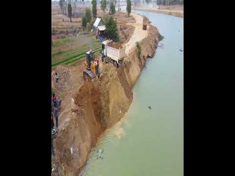 Relentless Road Reinforcement: D60P Dozer Fights Solid Rock with Nonstop Truck Loads