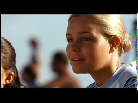 Blue Crush trailer frame: Anne Marie and friends laughing with boards in the sand