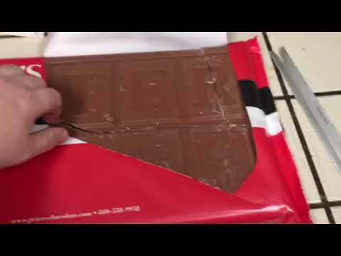 Guy opens package of a 10 pound chocolate bar.