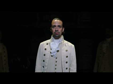 Hamilton official theatrical trailer thumbnail with the star logo and stage-lit ensemble, soundtrack cues teased for the big screen