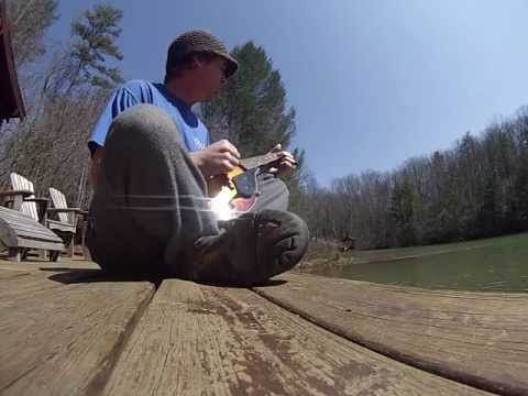 Jason chumley playing a lil mandolin by the lake.
