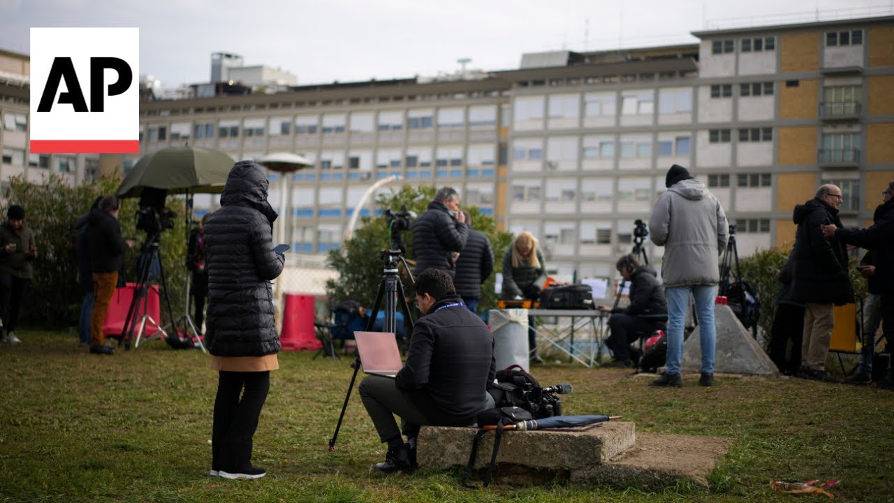 Media gathering at hopsital and faithful praying as Vatican says Pope Francis has pneumonia