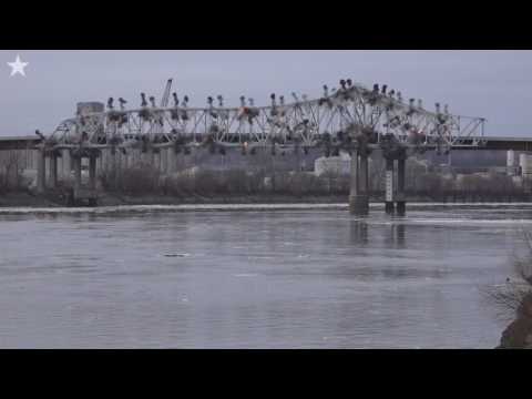 ミズーリ川の氷水にかかる橋に驚く若者たち