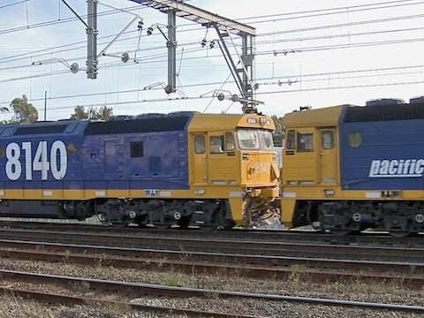Pacific National freight train in Sydney crossed by cityrail passenger train