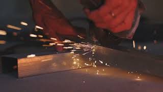 Man works circular saw sparks fly from hot metal man hard worked over 