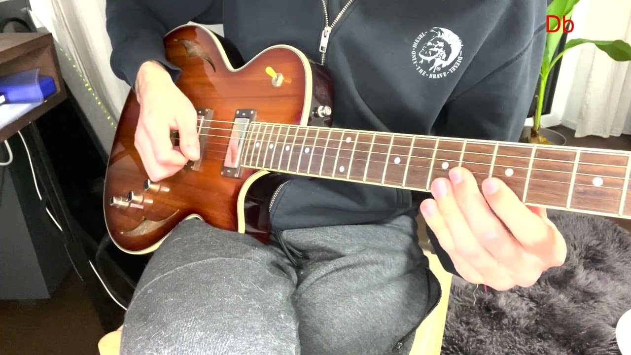 Guitarist playing a major 7#5 arpeggio voice leading exercise on electric guitar.