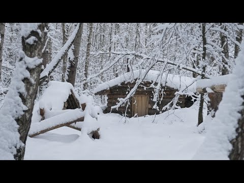 hiding in  cozy dugout during a snow storm , overnight stay in bushcraft shelter