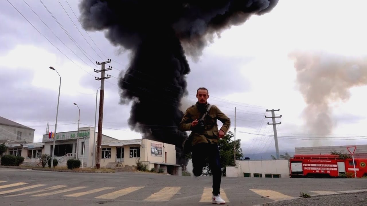 Man running from impact zone of explosive weapon in Nagorno-Karabakh