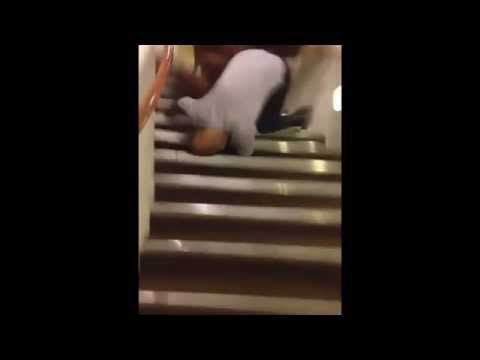 A bearded man rides a toy horse down stairs and falls