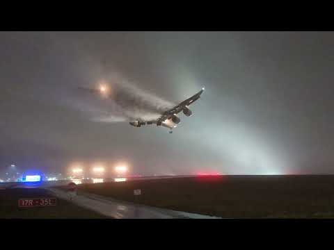 Airplane landing on runway leaves vortex trails in thick fog
