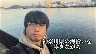 早朝に神奈川県の海沿いを歩きながら野宿の男