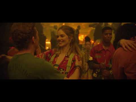 Trailer moment: the duo glimpsing their future selves—needle-drops set up comic whiplash