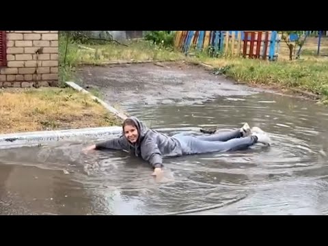 Beautiful russian girl enjoys the rain and dives into a puddle☺️